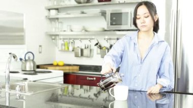 Asyalı kız mutfakta kahve içiyor
