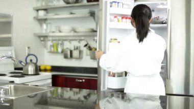 Asyalı kız bir pastayı buzdolabından alır.