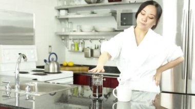 Asyalı kız mutfakta kahve içiyor