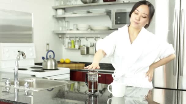 Asijská dívka je pití kávy v kuchyni — Stock video