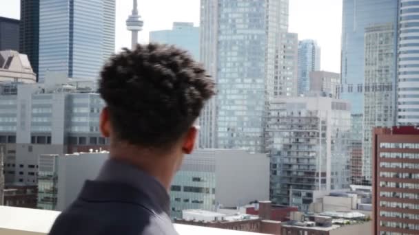 Афро-американский бизнесмен смотрит на городские здания — стоковое видео
