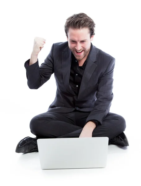 Attractive caucasian businessman working on laptop and shows success — Stock Photo, Image