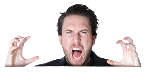 Ελκυστική καυκάσιος θυμωμένος επιχειρηματίας χειρονομίες με τα χέρια του πάνω από ένα μεγάλο φύλλο λευκό κενό — Φωτογραφία Αρχείου