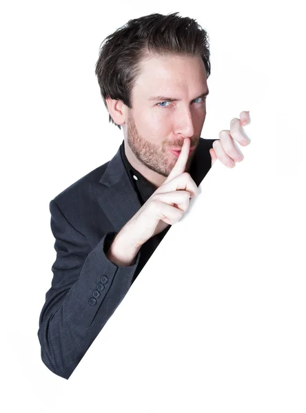 Empresário caucasiano atraente segurando um grande papel branco e mostra um mais silencioso — Fotografia de Stock