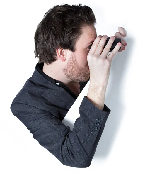 Attractive caucasian businessman looking through binoculars to the side — Stock Photo, Image