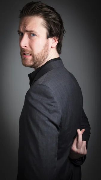 Attractive caucasian businessman crossing his fingers behind his back — Stock Photo, Image