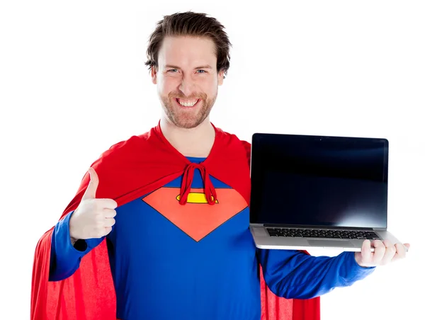 Attractive caucasian man dressed as superman holding a laptop and showing thumb up — Stock Photo, Image