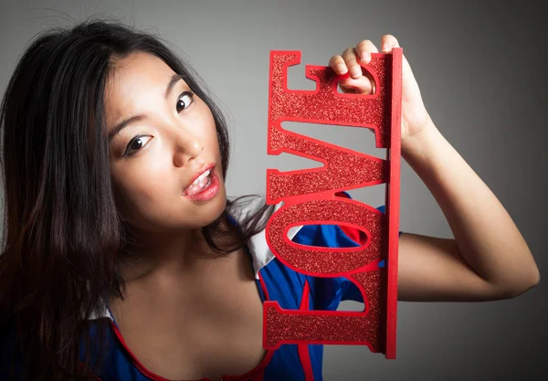 Flirting girl holding LOVE sign — Stock Photo, Image