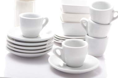 Beyaz arka planda izole edilmiş espresso bardakları ve çay tabakları.