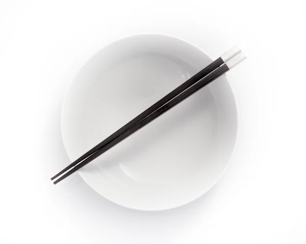 Chopsticks in empty bowl isolated on a white background — Stock Photo, Image