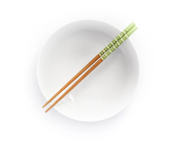 Chopsticks in empty bowl isolated on a white background — Stock Photo, Image