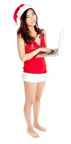 Сексуальный азиатский Санта Клаус держит ноутбук и улыбается — стоковое фото