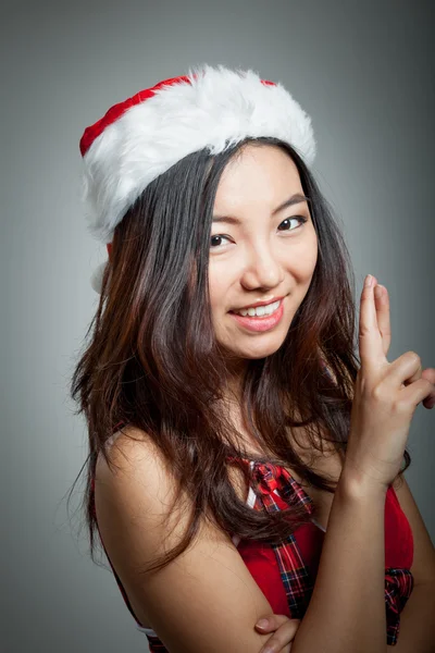 Sexy asiático santa claus en gris backgroound sonriendo con los dedos —  Fotos de Stock