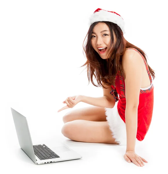 Sexy asian santa claus sitting with laptop and pointing — Stock Photo, Image