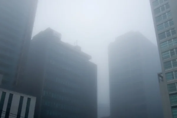 Skyscrapers in dense fog — Stock Photo, Image