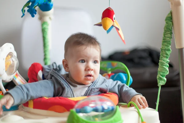 Criança sentada com brinquedos — Fotografia de Stock