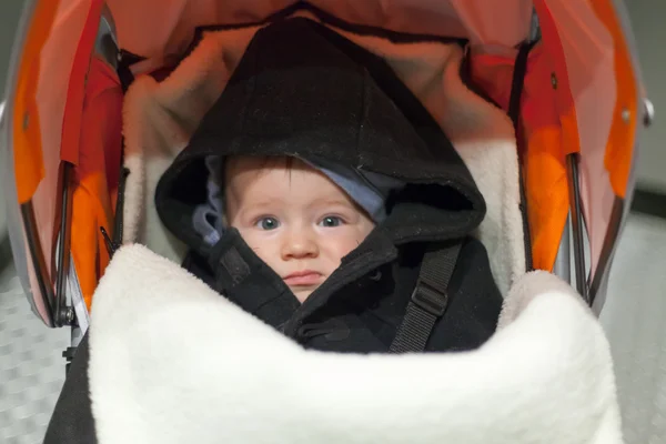 Dissatisfied boy in pram — Stock Photo, Image