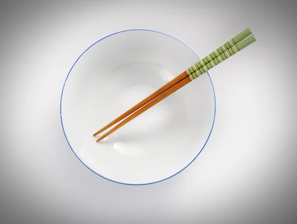 Палочки для еды в пустой миске — стоковое фото
