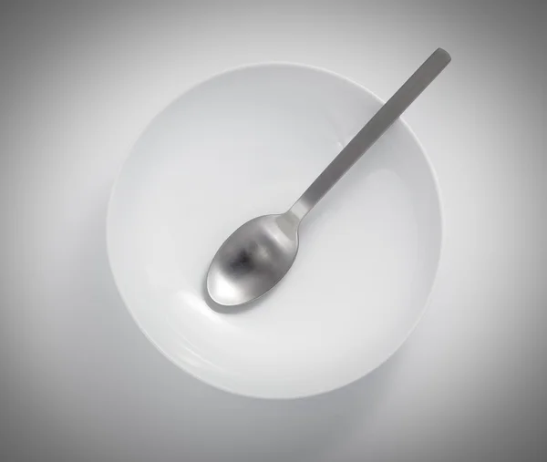 Spoon in an empty bowl isolated on a white background — Stock Photo, Image