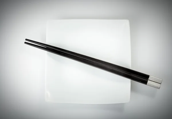 Black chopsticks in bowl — Stock Photo, Image