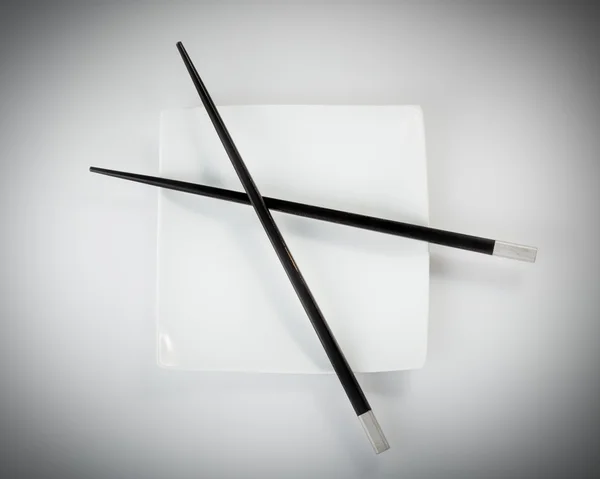 Black chopsticks in bowl — Stock Photo, Image