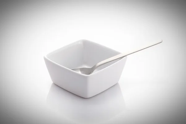 Spoon in a square bowl — Stock Photo, Image