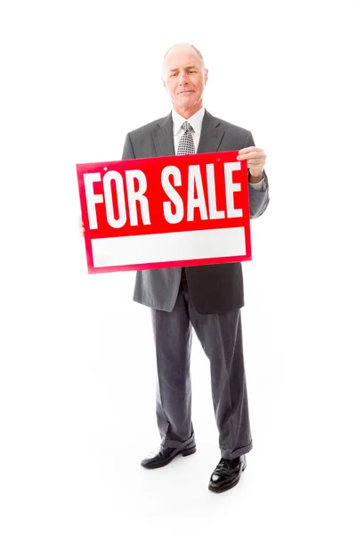 Businessman showing a for sale sign — Stock Photo, Image