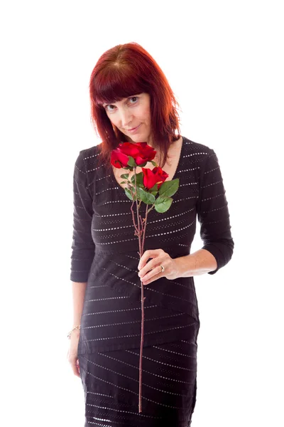 Vrouw ruikende rode roos — Stockfoto