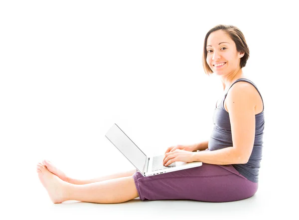 Smiling woman working on laptop — Stock Photo, Image