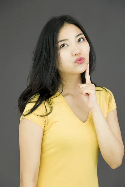 Mujer con dedo en la barbilla — Foto de Stock