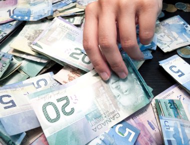 Hand picking Twenty Canadian Dollar Bill clipart