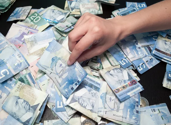 Mani della persona che raccolgono cinque dollari canadesi Bill — Foto Stock