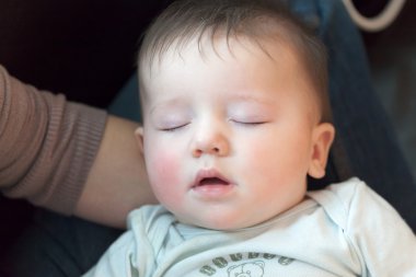 Annesinin kucağında uyuyan bebek