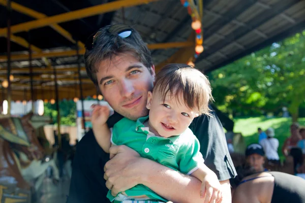 Hombre disfrutando de carrusel paseo con su hijo —  Fotos de Stock