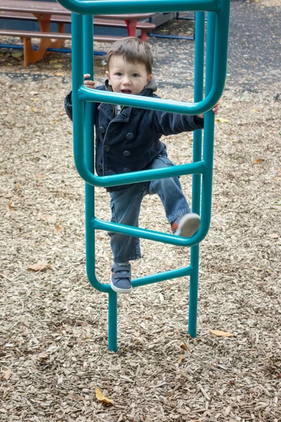 Niño escalando en un equipo de juego —  Fotos de Stock