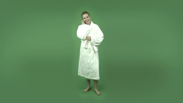 Girl in bathrobe talking on cell phone — Stock Video