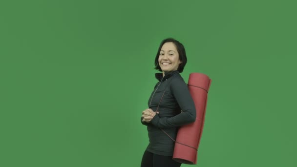 Chica deportiva sonriendo con esterilla de yoga — Vídeos de Stock