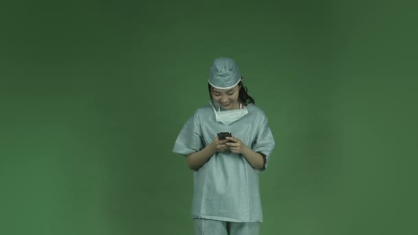 Aziatische vrouw arts chirurg sms mobiele telefoon — Stockvideo