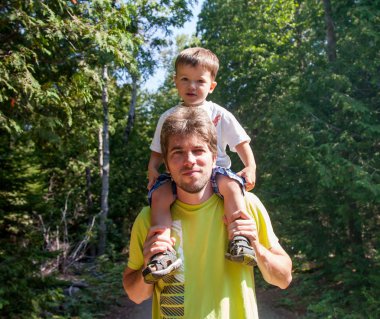 Oğlunu omuzlarında taşıyan bir adam