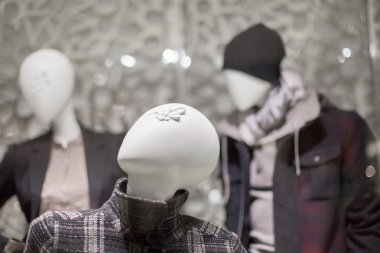 ceket giyen bir giyim mağazasında mankenler