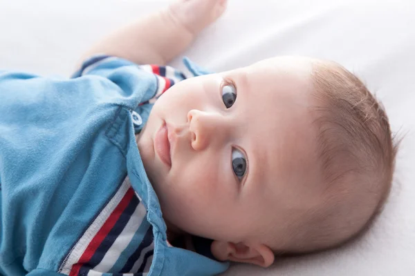 Baby jongen liggend op het bed — Stockfoto