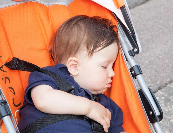 Niño durmiendo en un carro de bebé — Foto de Stock