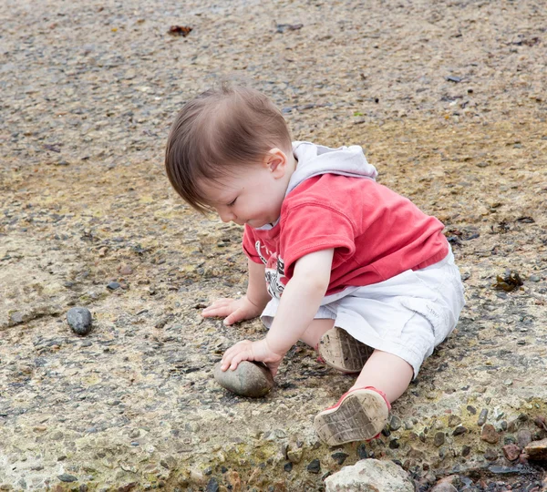 Ragazzo che gioca con rocce — Foto Stock