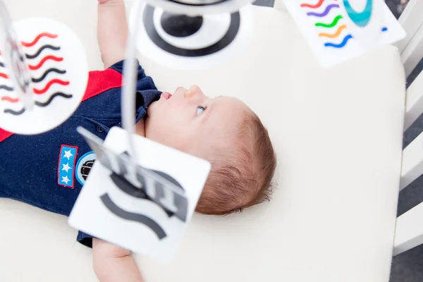 Baby boy lying in a crib — Stock Photo, Image