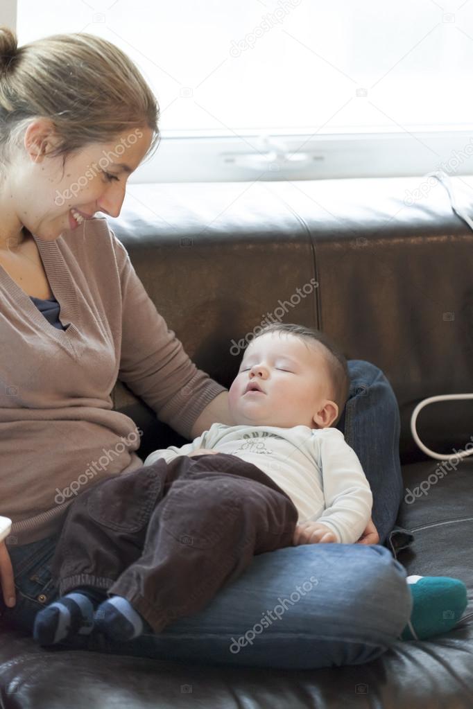 Baby sleeping in the lap of his mother