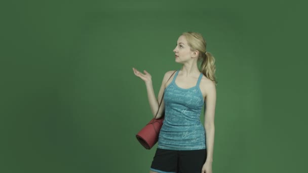 Mujer en traje deportivo presentando y señalando — Vídeos de Stock