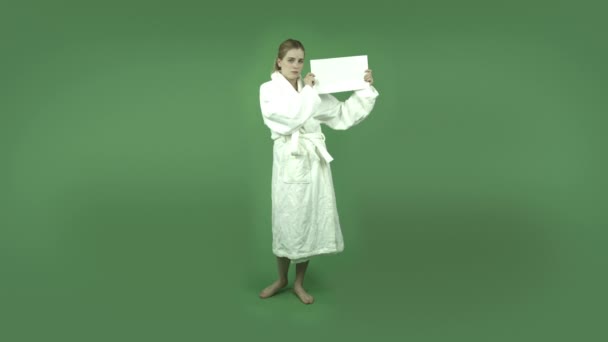 Girl in bathrobe worried with blank sign — Stock Video