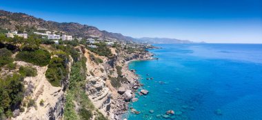 Uçurumun kenarındaki güzel kıyı kasabası, açık gökyüzüne karşı mavi deniz.