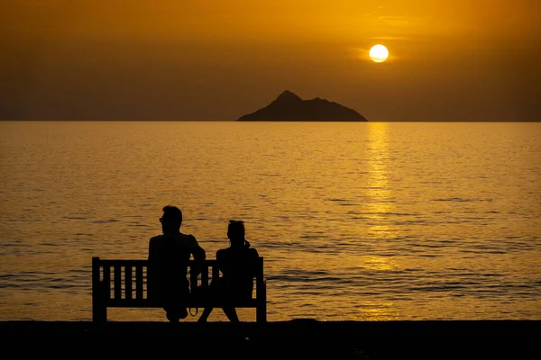 Silhouette Coppia Rilassante Sulla Panchina Riva Mare Durante Bellissimo Tramonto — Foto Stock