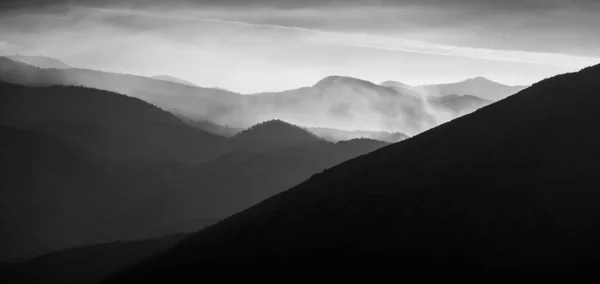 Silhueta Cadeias Montanhosas Cobertas Nevoeiro Contra Céu — Fotografia de Stock